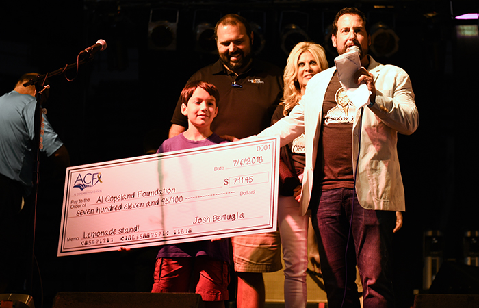 The Bertuglias present a check to Al and Liz Copeland at Chicken Jam